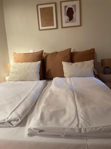 ein Bett mit zwei weißen Laken und zwei Kissen in der Unterkunft Ferienwohnung Heidi in Prien am Chiemsee
