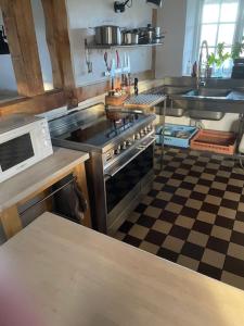 cocina con fogones y suelo a cuadros en 10 min från Malmö/Lund, en Staffanstorp