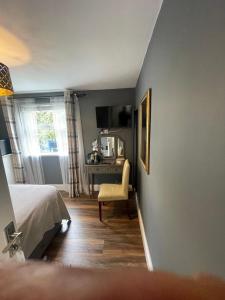 a bedroom with a bed and a chair and a desk at Skyline Guesthouse Newquay in Newquay