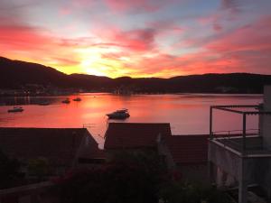 a sunset over a body of water with boats in it at JASMINE DELUXE APARTMENT with super-king bed, large sun terrace and spectacular views in Vis