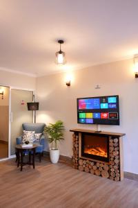 ein Wohnzimmer mit einem Kamin und einem Flachbild-TV in der Unterkunft ORTUS Murree 2 in Murree