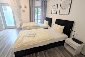 two twin beds in a room with wooden floors at Zentrales City Apartment im Zentrum aber trotzdem ruhig in Bamberg