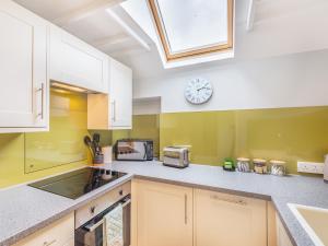a kitchen with a sink and a clock on the wall at Bay - Uk44720 in Ravenscar