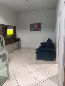 ein Wohnzimmer mit Couch und Flachbildfernseher in der Unterkunft Conexão conforto in Vespasiano