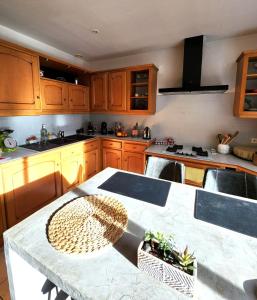 a kitchen with wooden cabinets and a table with a basket at La Carrière in Pont-Saint-Martin