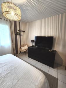 a bedroom with a bed and a flat screen tv at La Carrière in Pont-Saint-Martin
