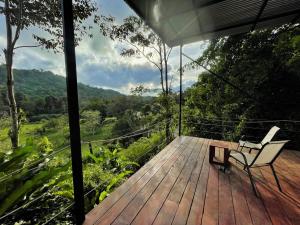 a wooden deck with a chair and a table at Casita Anya in Hone Creek