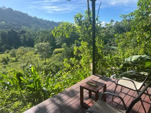 a wooden deck with two chairs and a table at Casita Anya in Hone Creek +16 photos