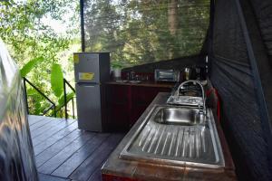 a kitchen in a tent with a sink and a refrigerator at Casita Anya in Hone Creek