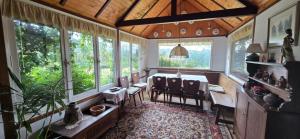 ein Raum mit Tisch und Stühlen und Fenstern in der Unterkunft Los Alerces, Villa Berna in La Porteña