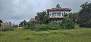 ein kleines Haus mitten auf einem Feld in der Unterkunft Los Alerces, Villa Berna in La Porteña