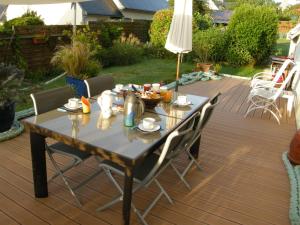 une table et des chaises sur une terrasse dans l'établissement Chambres d'hôtes de Pont C'Hoat, à Névez