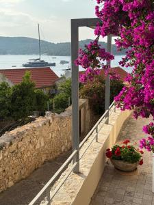 a walkway with flowers and a view of the water at JASMINE DELUXE APARTMENT with super-king bed, large sun terrace and spectacular views in Vis