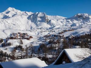 a snow covered mountain with a house in the foreground at Triplex 7 pers avec grande terrasse sur pistes - FR-1-455-73 in La Plagne +4 photos