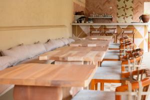 a row of wooden tables and chairs in a restaurant at Casa Nära Hotel in El Sucio