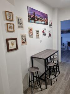Una mesa y taburetes en una habitación con cuadros en la pared. en Affittacamere Ely, en San Giorgio di Nogaro