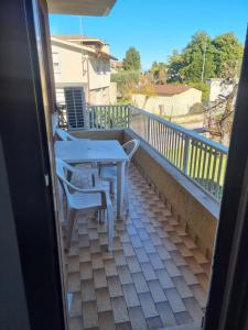 eine Terrasse mit Tisch und Stühlen auf einem Balkon in der Unterkunft Affittacamere Ely in San Giórgio di Nogaro