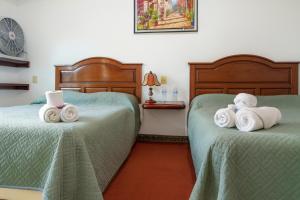 two beds with towels on them in a room at Hotel Casa Maximiliano in Tepoztlán +3 photos