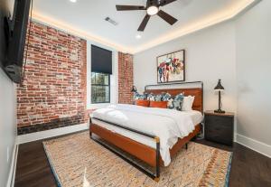 a bedroom with a bed and a brick wall at Chic Downtown Retreat Fireplace Game Area in Hot Springs