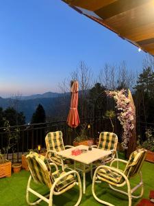a table and four chairs on a patio with a view at Ortus - Murree Hills in Murree
