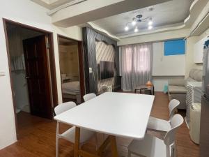 Una sala de estar con una mesa y sillas blancas. en 羅東二房電梯包棟近火車站, en Luodong