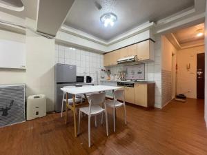 Una cocina con una mesa y sillas en una habitación. en 羅東二房電梯包棟近火車站, en Luodong 4 fotos más