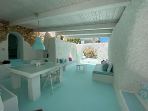 a white room with a table and a couch at Borgo Acqua in Lampedusa