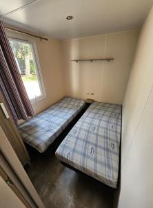 twee bedden in een kleine kamer met een raam bij Mobil Home 3Ch - 6Pers 15min Europa PARK 330C in Boofzheim +7 foto's