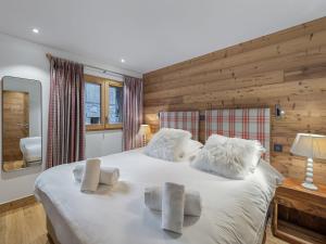une chambre avec un grand lit avec des oreillers blancs dans l'établissement Charmant appart avec terrasse, parking, WIFI - FR-1-452-390, à Saint-Martin-de-Belleville