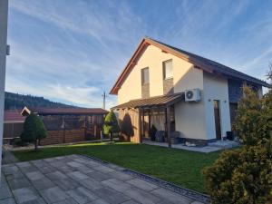 a house with a patio and a backyard at Apartmán Art in Zuberec