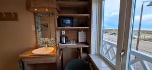 une petite salle de bain avec un lavabo et une fenêtre dans l'établissement Bed&Breakfast aan Strand, à Katwijk aan Zee