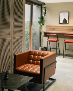 a brown leather couch in a living room with a table at Vesta Rooms in Antalya +28 photos