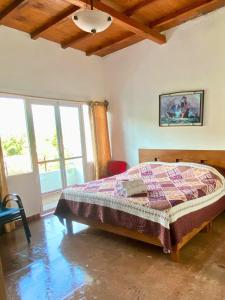 Un dormitorio con una cama en una habitación con ventanas. en Hotel Casa Maximiliano, en Tepoztlán