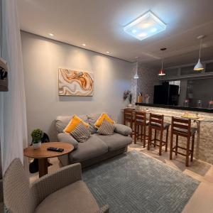 a living room with a couch and a table and a bar at Conforto Frente ao Mar - Areia Preta in Guarapari