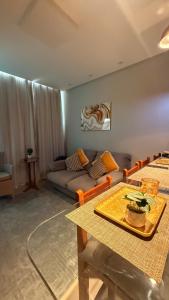 a living room with a table and a couch at Conforto Frente ao Mar - Areia Preta in Guarapari