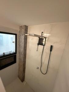 a bathroom with a shower with a light on the wall at Conforto Frente ao Mar - Areia Preta in Guarapari +28 photos