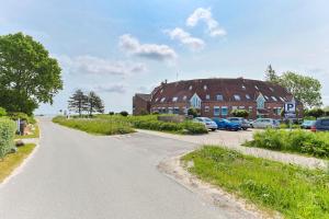 克隆斯加尔德Ferienwohnung Familienkoje mit Meerblick Kronsgaard的一条通往停满汽车的大型建筑物的道路