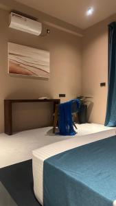 a bedroom with a bed with blue sheets and a fan at Serenity Villa in Dickwella