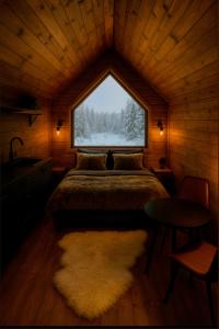 a bedroom with a bed and a window in a cabin at Arctic circle cabin 1 in Rovaniemi