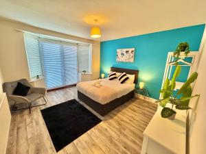 a bedroom with a bed and a chair in it at Beachside Haven in Centre with Garden and Parking - 5 Mins Walk to The Beach in Bournemouth