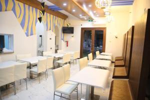 a dining room with white tables and white chairs at SAJ Farm Inn in Ibrā