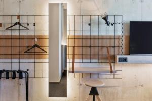 een kamer met een kruk en een betegelde muur bij Moxy Zurich in Zürich