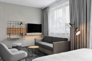 een hotelkamer met een bank en een tv bij Moxy Zurich in Zürich