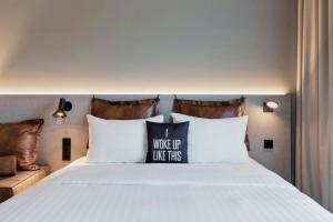een bed met een kussen waarop staat dat je zo wakker wordt bij Moxy Zurich in Zürich +13 foto's