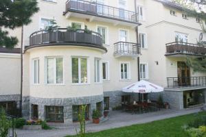 un gran edificio blanco con patio y sombrilla en Apartamenty Paradis Zakopane, en Zakopane