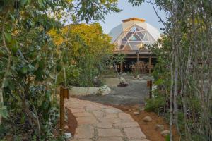 um jardim com um caminho de pedra que leva a um edifício em Capão Domo em Vale do Capao