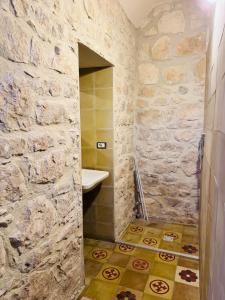 a bathroom with a sink and a stone wall at Casa Betta in Modica +48 photos
