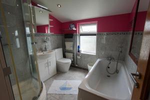 a bathroom with a tub and a toilet and a sink at Charming 2 BDR Home with Garden and Light in London