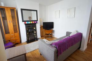 a living room with a couch and a fireplace at Charming 2 BDR Home with Garden and Light in London +15 photos