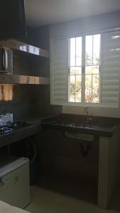 a kitchen with a sink and a window at Studio Jaguary - Monte Verde in Camanducaia